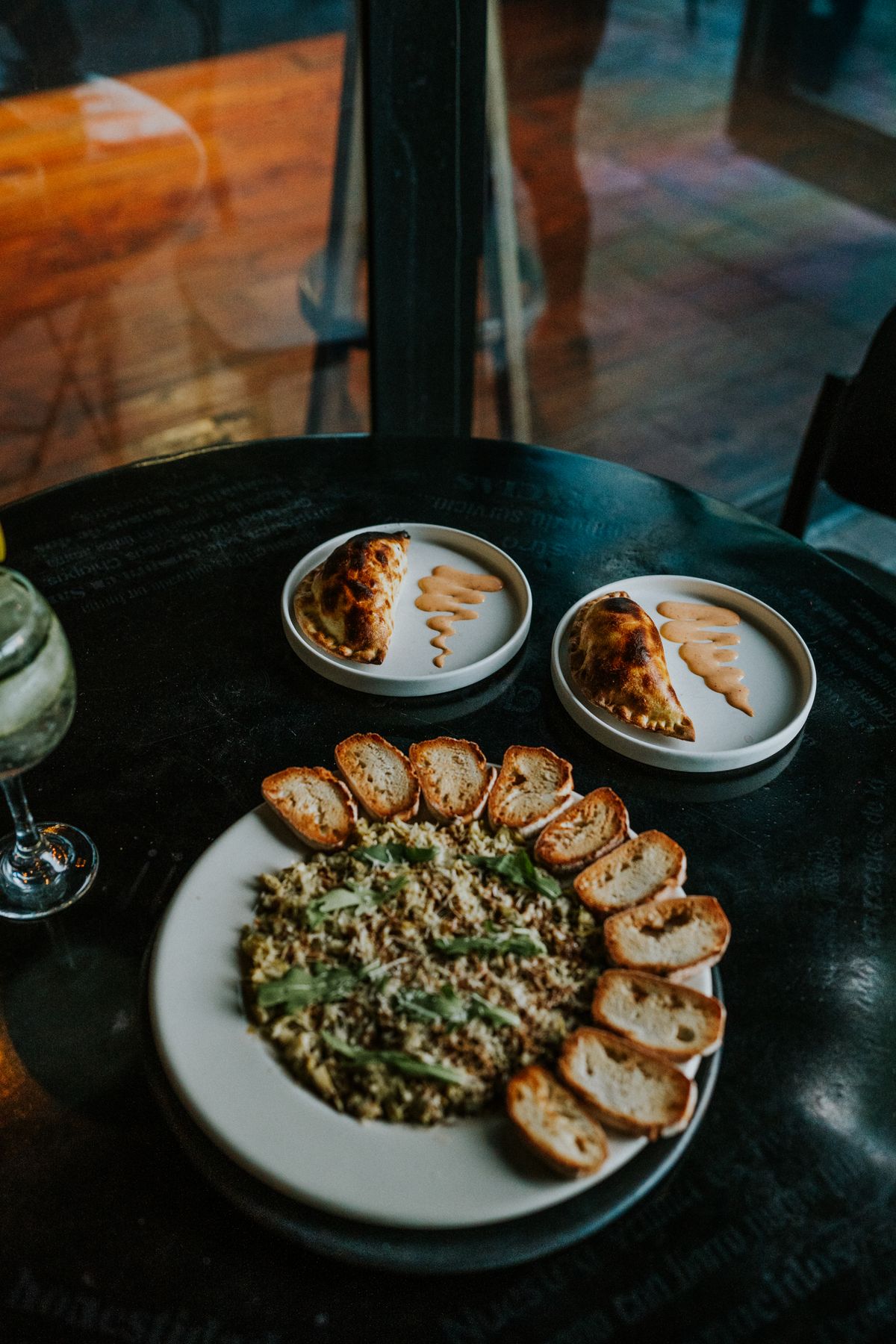 A plate of food on a table with two glasses of wine
