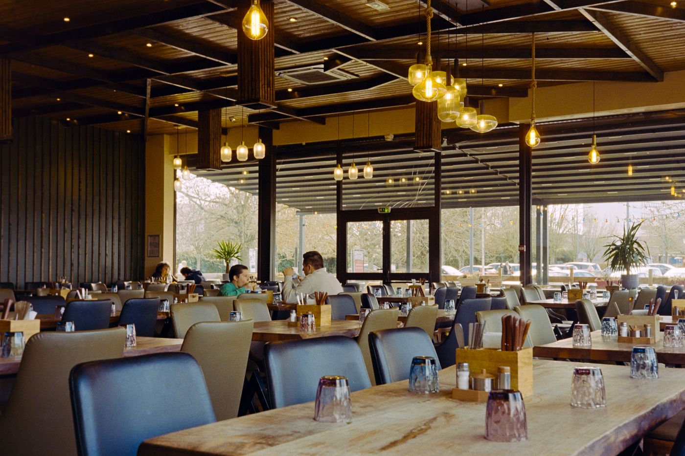 The dining room in the afternoon, wooden tables and warm light
